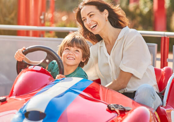 Madre e hijo disfrutando en una atracción infantil de Ferrari Land