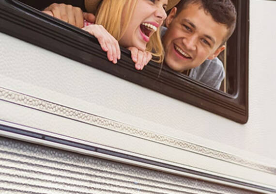 Chico y chica saliendo sonriendo de una ventana