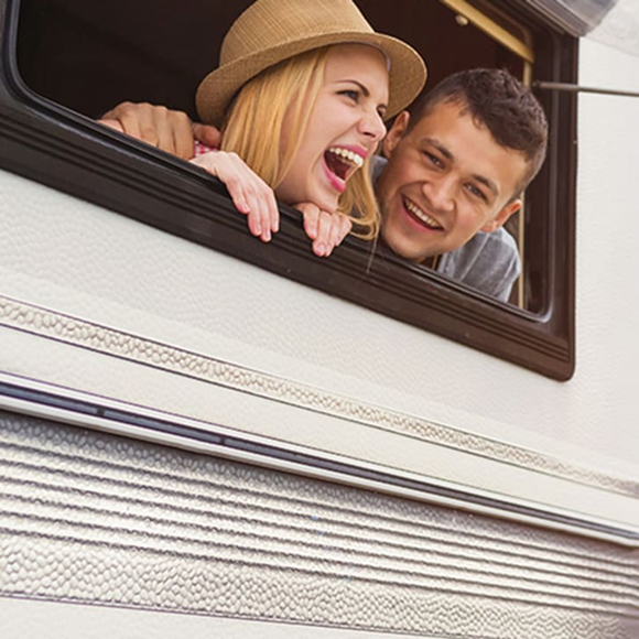 Chico y chica saliendo sonriendo de una ventana