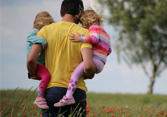 Padre con sus dos hijas a cuestas