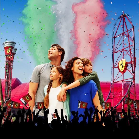 Familia disfrutando del GP Festival en Ferrari Land, con las atracciones y la decoración Ferrari al fondo