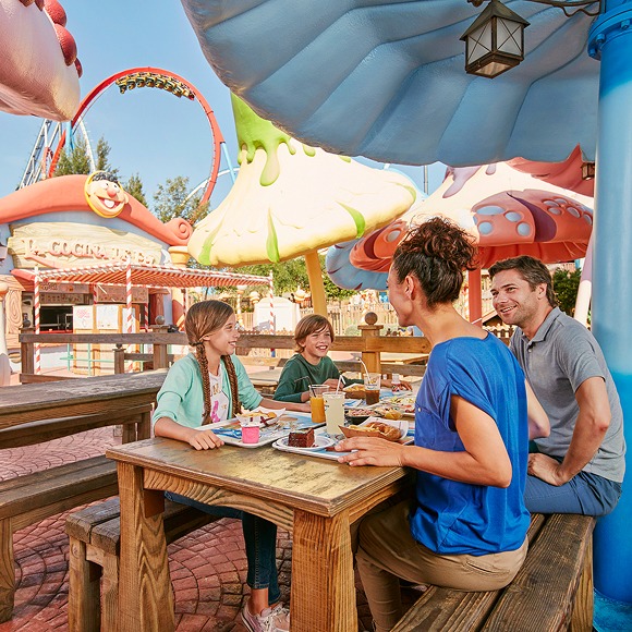 Familia disfrutando de una comida en un restaurante temático de PortAventura World