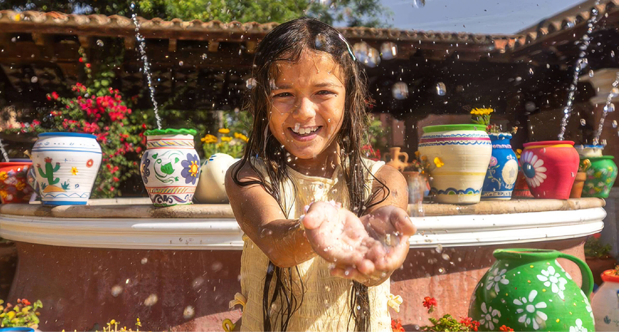 Niña refrescándose con agua en un Refresh Point de PortAventura