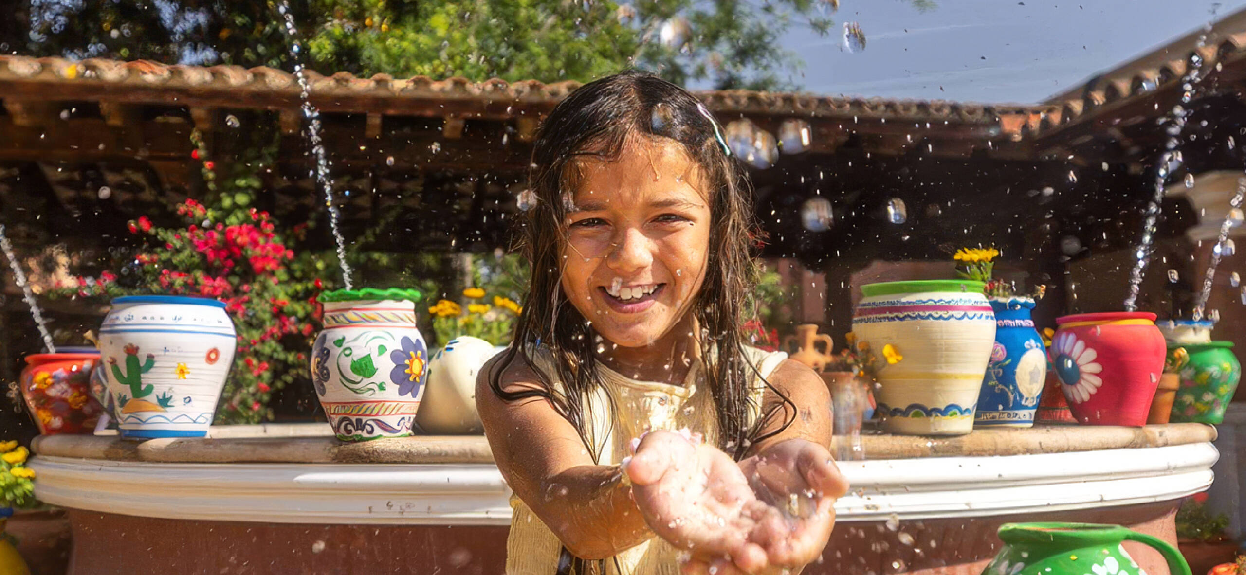 Niña refrescándose con agua en un Refresh Point de PortAventura